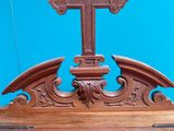 an old wooden cross on a stand with a blue wall in the background