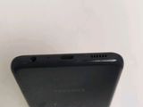 the back of a black cell phone sitting on top of a white table