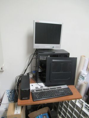 un bureau d'informatique équipé d'un écran, d'un clavier, d'une souris et d'autres appareils électroniques