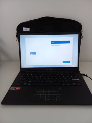 un ordinateur portable noir posé sur une table blanche