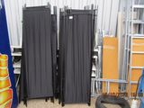 four black folding chairs in a room next to a wall