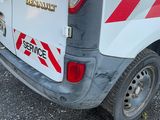 une camionnette blanche avec des bandes rouges et blanches garée dans un parking