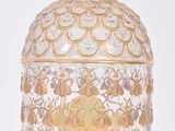 a glass bottle with a gold decoration on it
