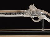 a glass gun on a stand with a black background