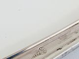 a silver spoon with a handle on a white surface