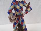 figurine of a man in a clown costume holding a baseball bat