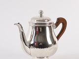 an antique silver teapot with wooden handle on a white background