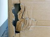 a cardboard box with a hole in it that has been torn open