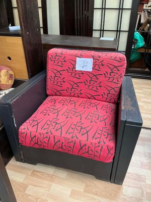 une chaise rouge et noire ornée d'un motif de graffiti, placée devant un miroir
