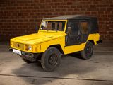 a yellow jeep that is parked in front of a brick wall