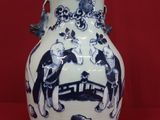 un vase bleu et blanc posé sur une surface rouge
