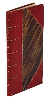 an old book with a red cover and gold trim on a white background