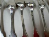 several spoons and forks are lined up on a white surface