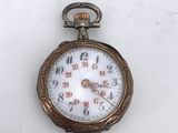 a pocket watch that is sitting on a white surface