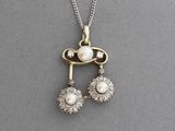 un gros plan sur un collier orné de deux perles