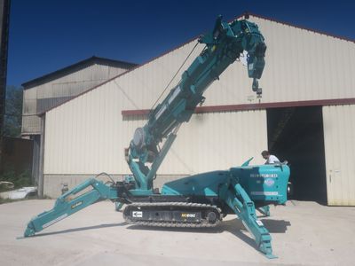 a crane that is sitting on the ground in front of a building