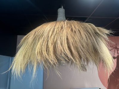 un chapeau de paille suspendu au plafond d'une pièce