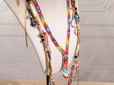 multicolored beaded necklace on a mannequin on a wooden table