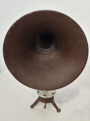 un chapeau marron posé sur un trépied en bois