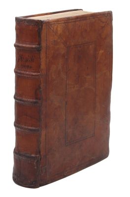un vieux livre relié en cuir posé sur une surface blanche
