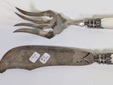 two forks and a knife on a white table