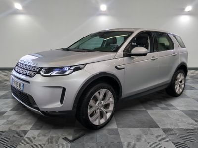 un Land Rover argenté garé dans un garage au sol carrelé