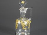 une carafe en verre ancienne ornée d'un motif doré