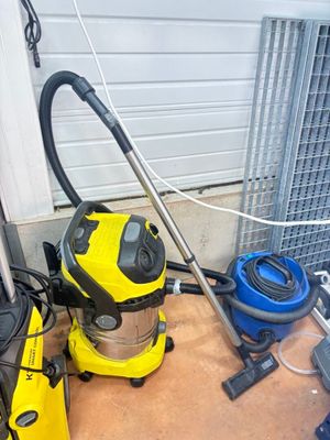 un aspirateur jaune et un aspirateur bleu posés par terre