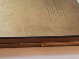 an old book sitting on top of a white table next to a window