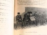 un vieux livre sur lequel figure la photo d'un groupe d'hommes assis sur un banc