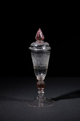 an old glass with a red top sitting on top of a table