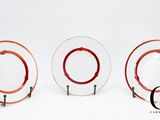 trois assiettes en verre recouvertes de peinture rouge, posées les unes à côté des autres