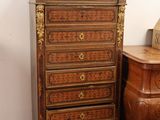 a small chest of drawers next to a small table