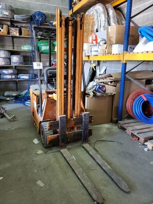 a forklift in the middle of a room with lots of boxes