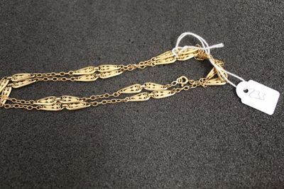 un bracelet en chaîne d'or auquel est attachée une étiquette