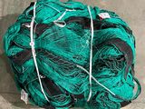 a large pile of green fishing nets on the ground