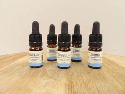 trois flacons d'huile de CBD posés sur une table en bois