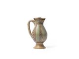 un petit vase posé sur une surface blanche