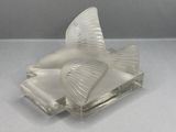a glass bird that is sitting on a glass block