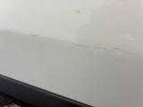 a white car that has a hole in the side of it
