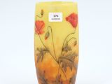 a yellow vase with red flowers painted on it