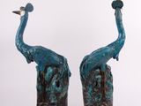 pair of blue and black sculptures of two peacocks on a white background