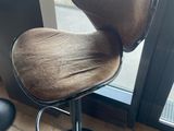 une chaise marron posée devant une fenêtre