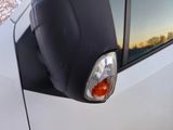 a close up of a car ' s side mirror with the reflection of the sky in the window