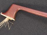 a close up of a wooden axe with a long handle