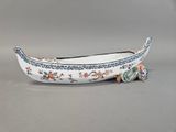 a small boat shaped like a boat with flowers on it