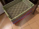 une personne debout dans une cuisine, avec un panier posé par terre