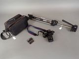 a bag, camera, tripod, and other items laid out on a table