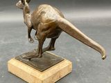 bronze statue of a kangaroo on a marble base on a gray background