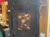 a grandfather clock in the middle of a room with a red wall